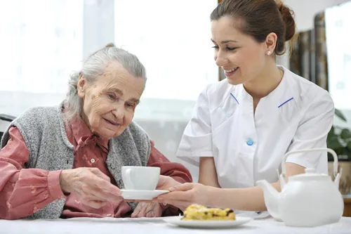 Betreuerin unterstützt eine Seniorin – Verhinderungspflege zur Entlastung pflegender Angehöriger